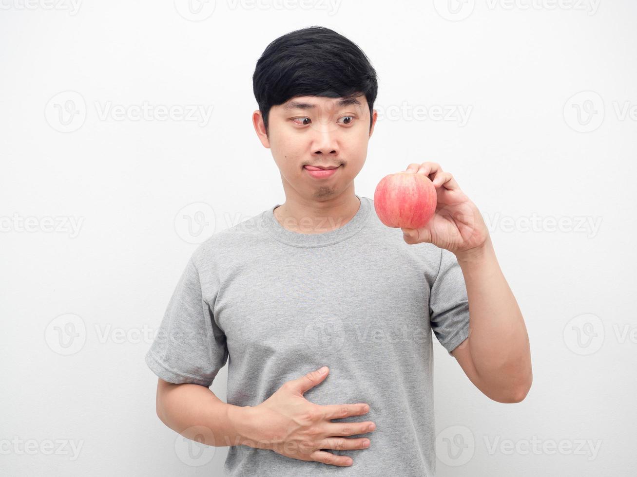 gesto de hombre hambriento quiere comer manzana rasgada en la mano foto