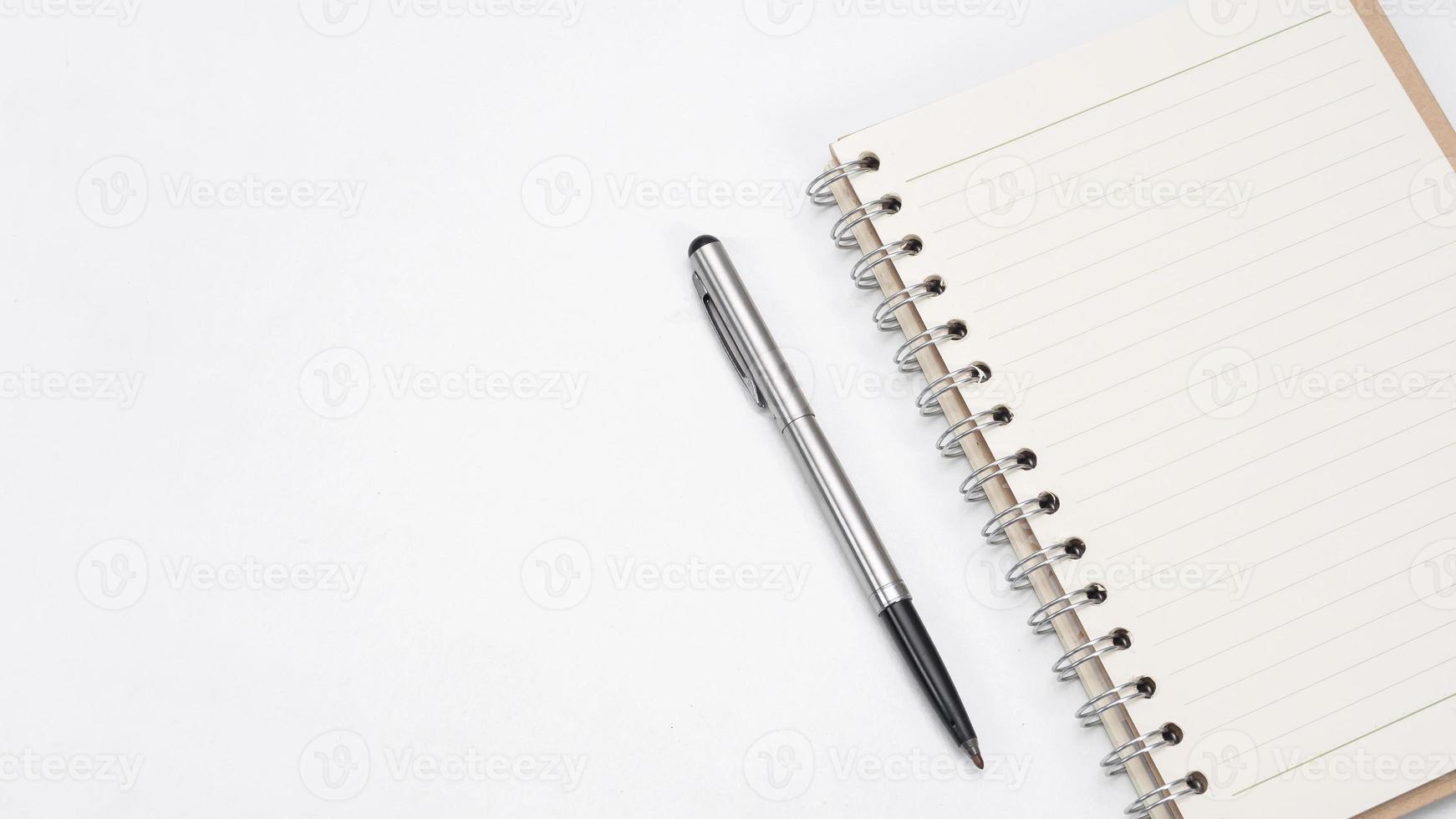 Silver pen and notebook blank page on the table top view copy space photo