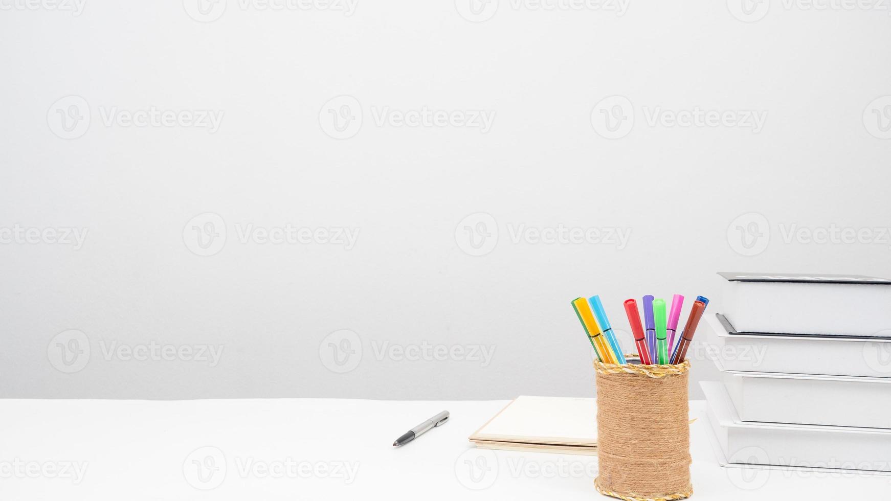 Pencil box pen books on the table copy space white background photo