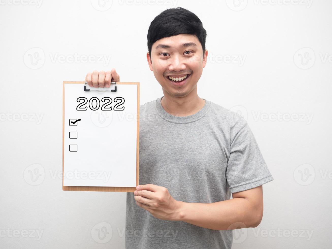 Man smiling showing document wood board with 2022 message and check list portrait photo