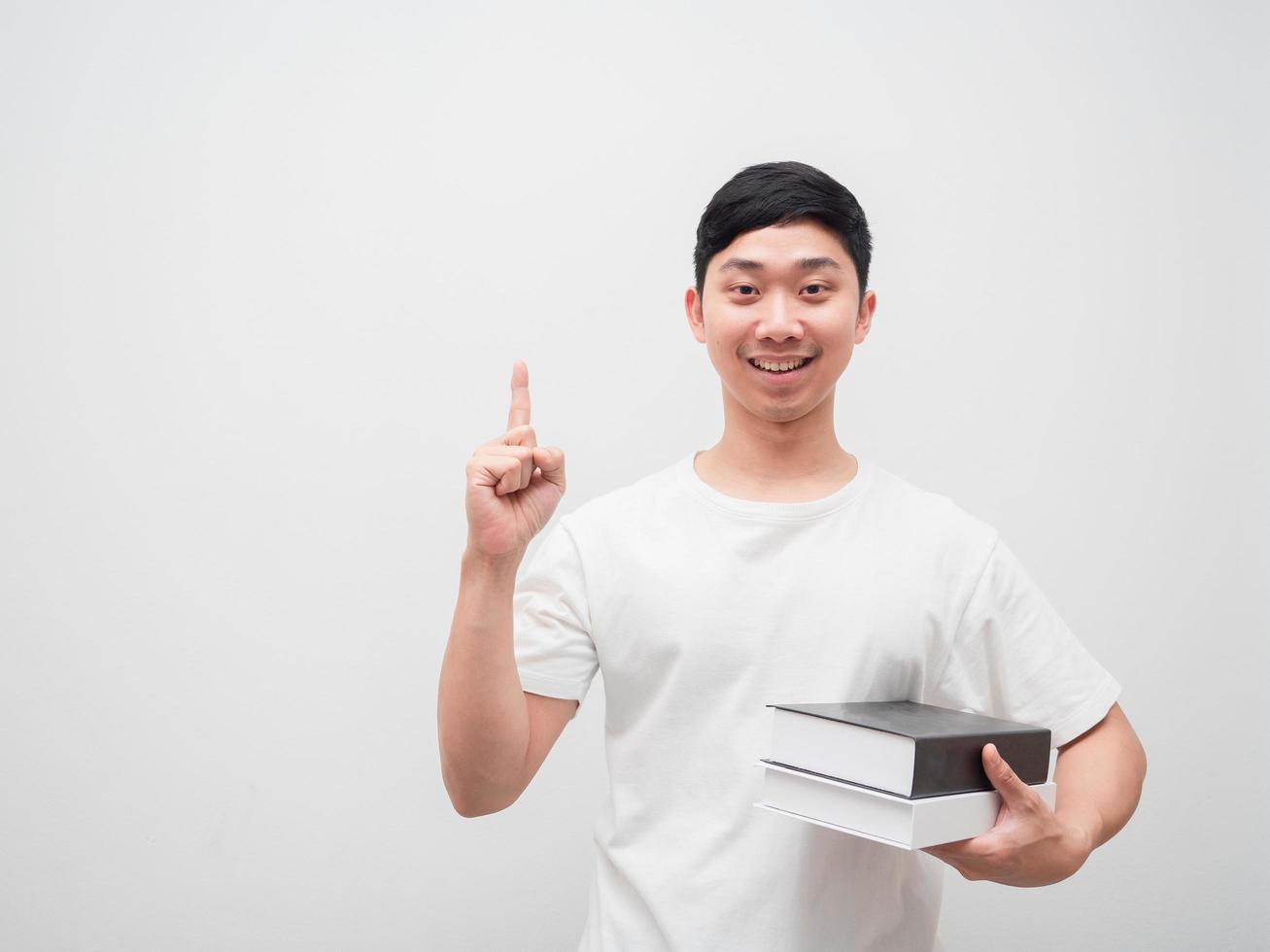 hombre asiático camisa blanca sonrisa feliz obtener concepto de idea sosteniendo libros en la mano sobre fondo blanco aislado foto