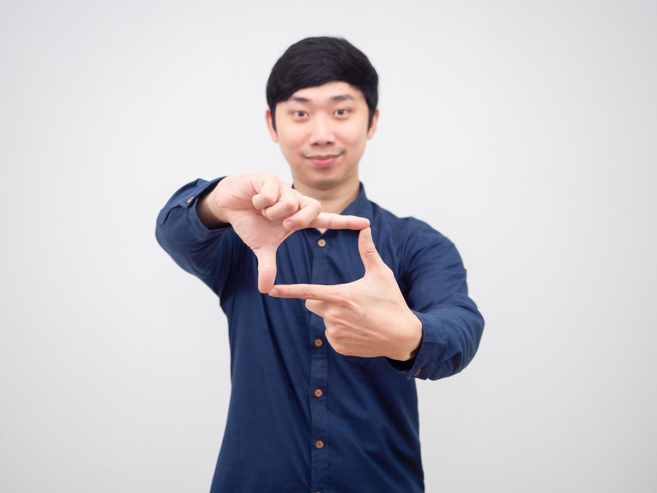 el hombre asiático hace su dedo cuadrado de la mano con una sonrisa feliz en la cara de fondo blanco foto