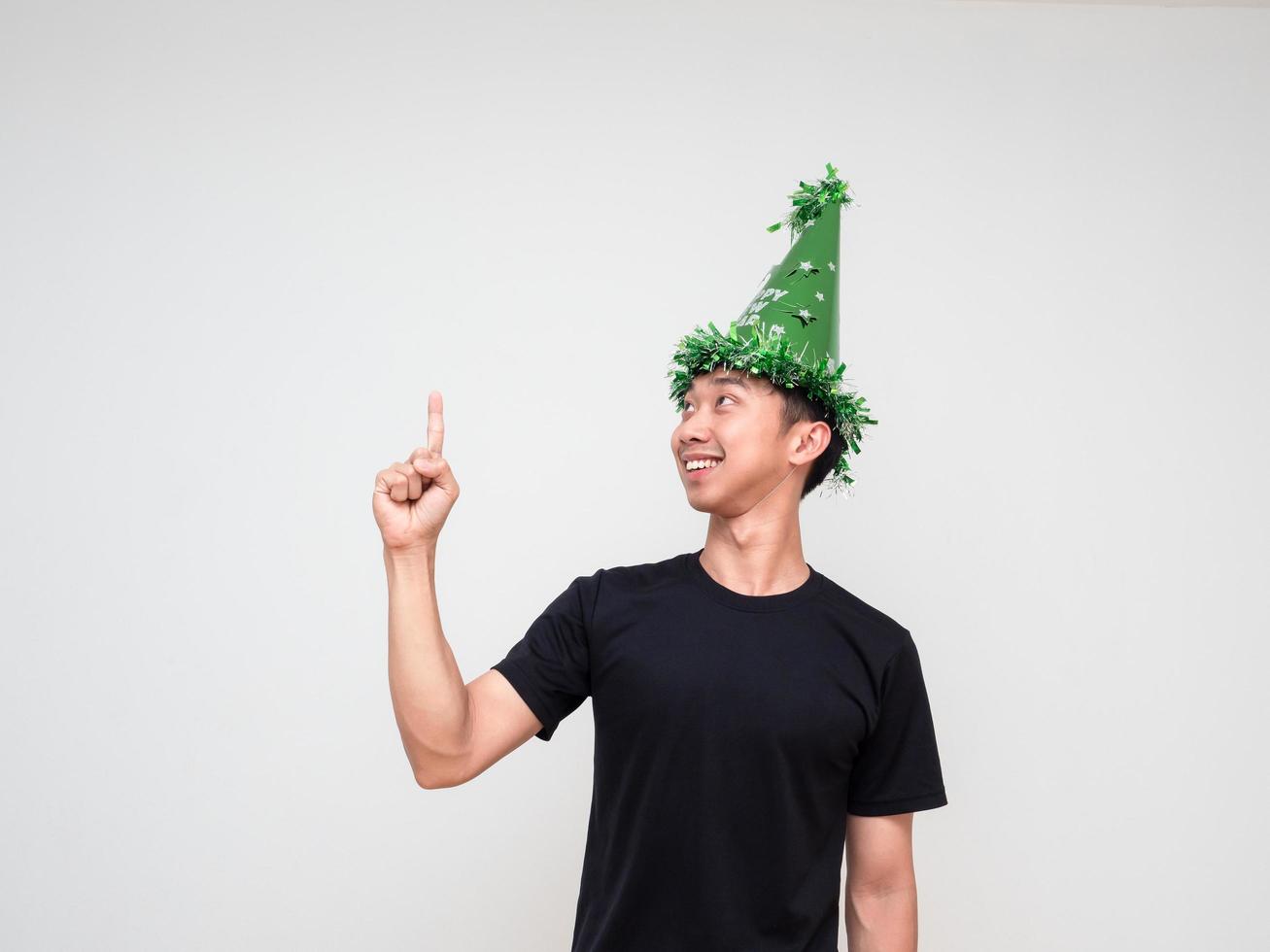 Portrait young man happy face with green hat point right finger above look at right hand and smile on white isolated background photo