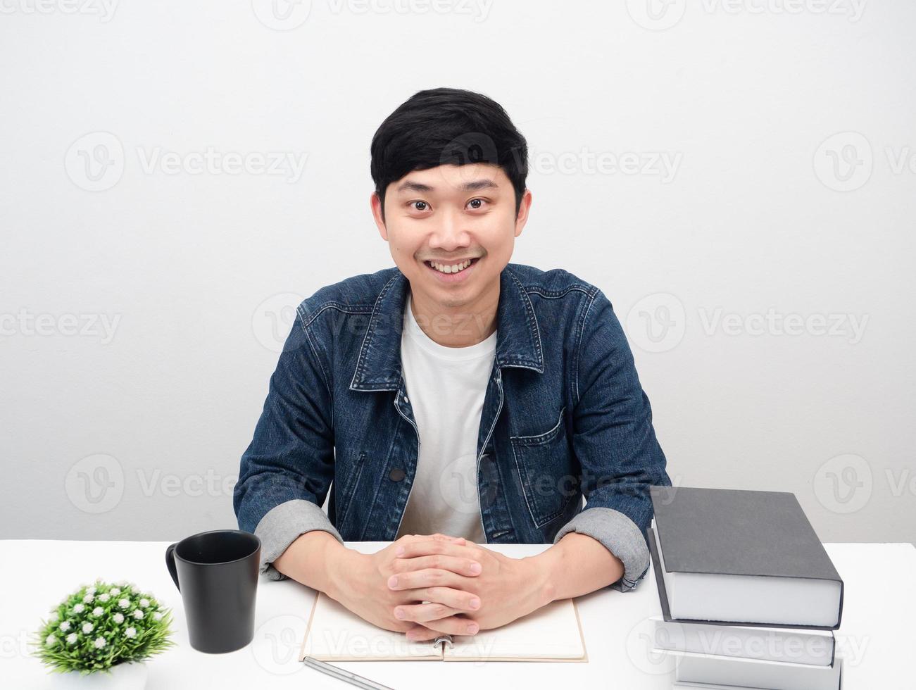 Man sit at the workspace table smiling portrait white background photo