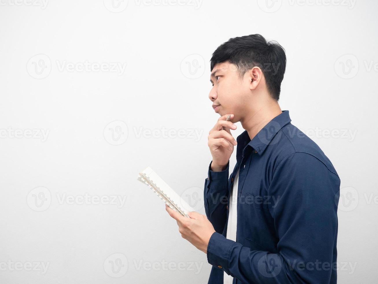 Side view man holding diary book and gesture thinking about something photo