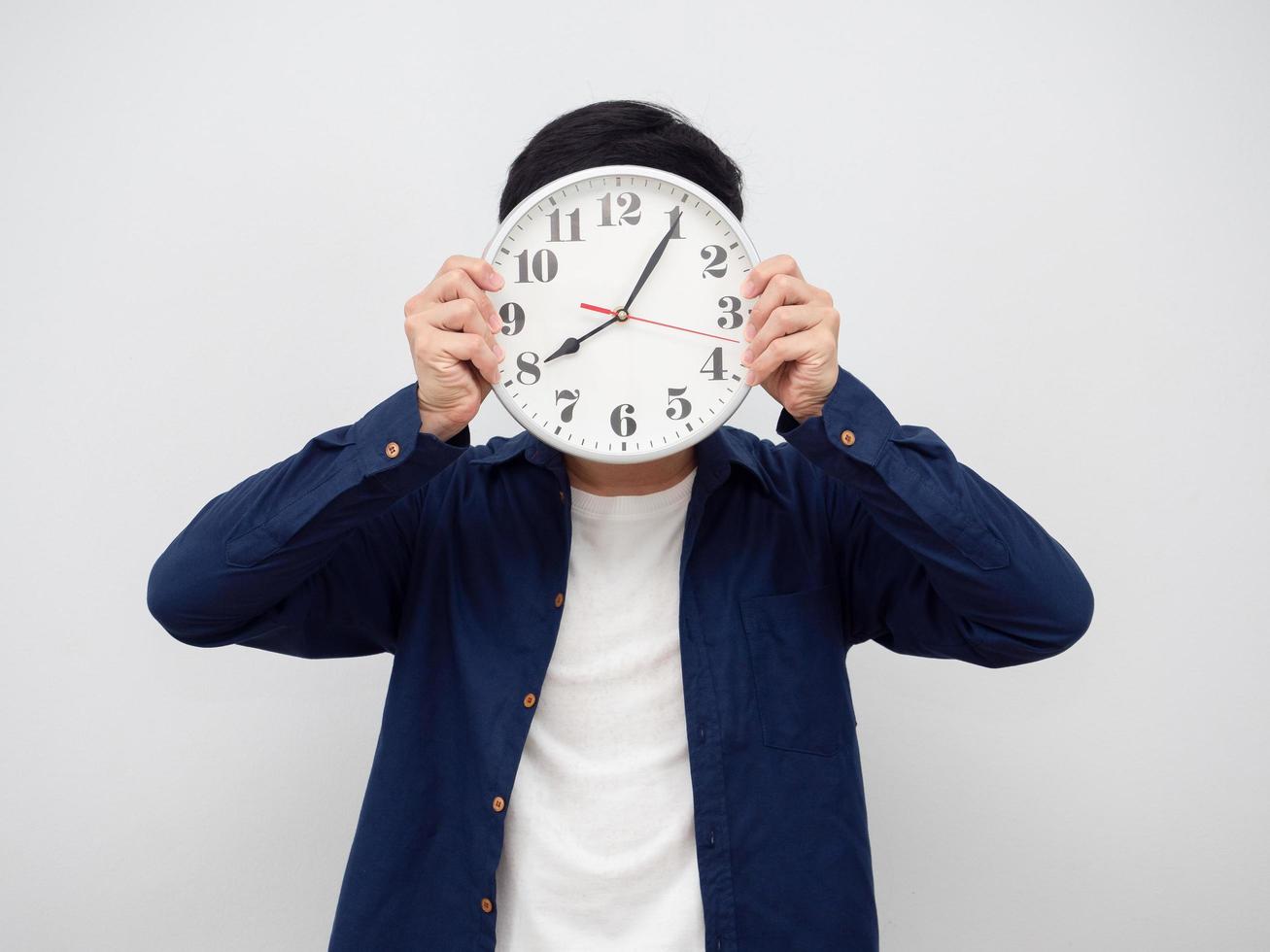 el hombre cierra su rostro con un reloj analógico retrato de fondo blanco foto