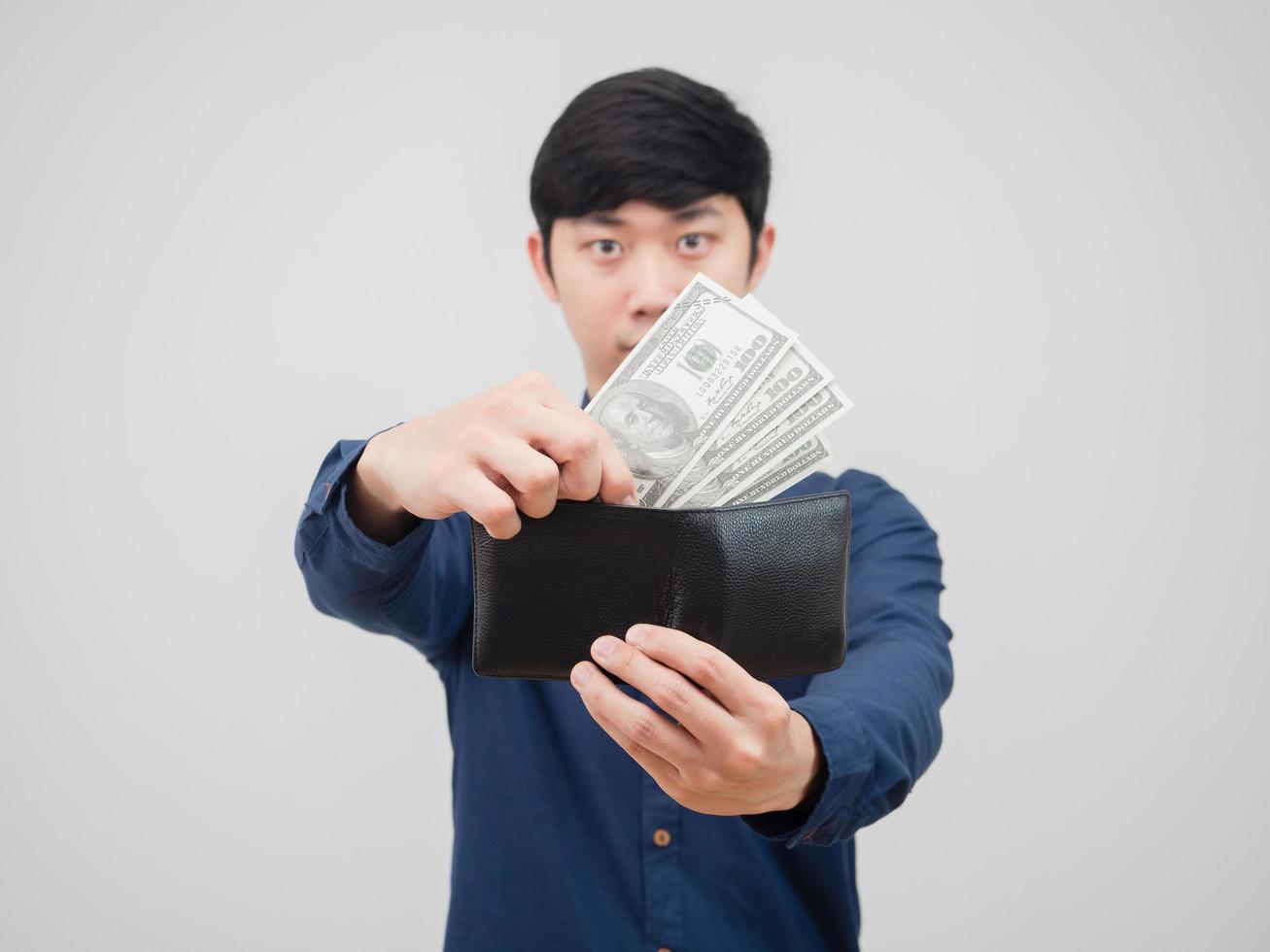 el hombre toma dinero de su billetera con fondo blanco foto