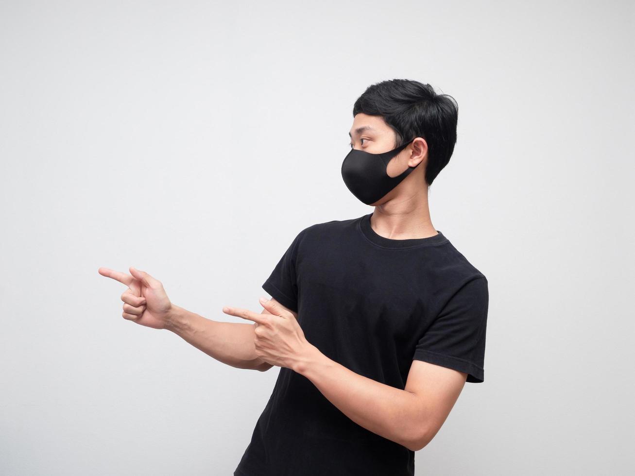 Portrait man wearing mask double point finger and looking at left side on white background photo