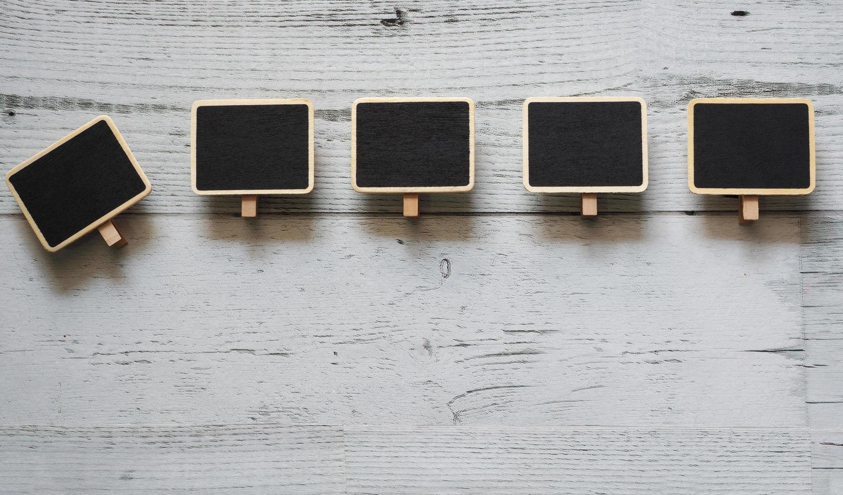 Five small clip chalkboard array line on white wood table nature shadow below space,Idea signboard concept photo