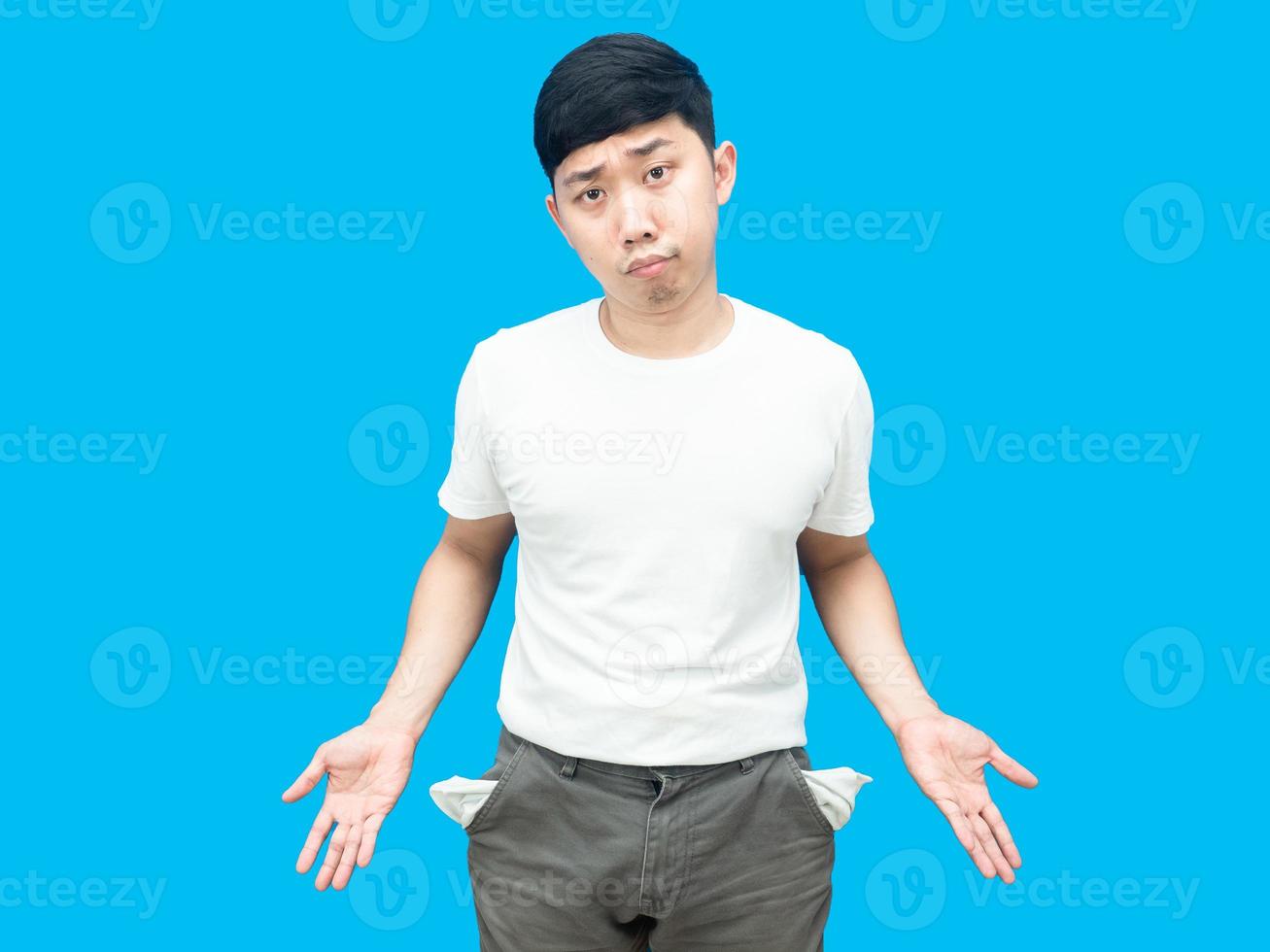 Poor man gesture no money show empty shorts pocket blue background photo