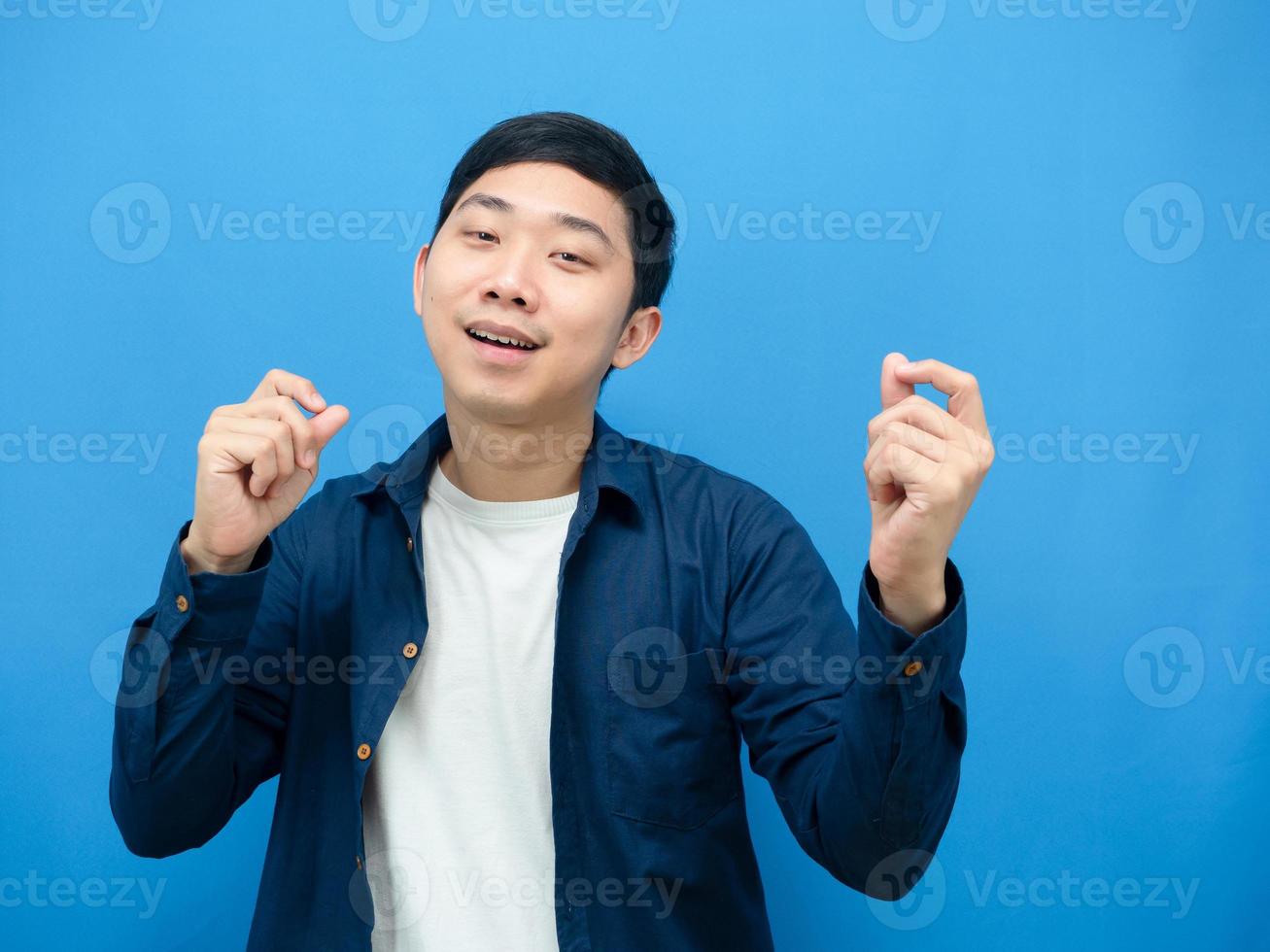 hombre asiático feliz emoción gesto gracioso baile fondo azul foto