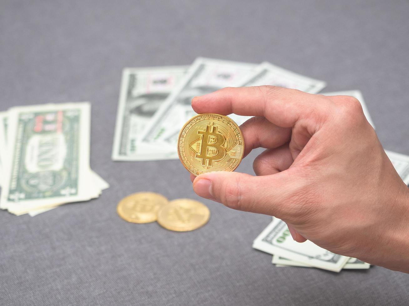 mano sosteniendo bitcoin dorado y fondo de dinero foto