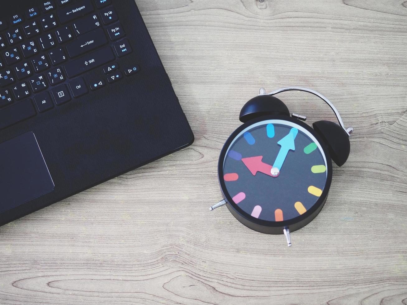 Top view laptop keypad and retro analog clock vintage style on wooden table work photo