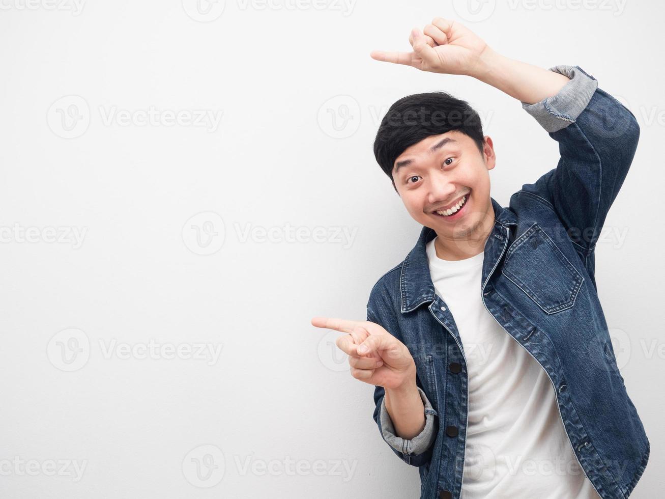 Asian man jeans shirt smiling gesture pointing finger at copy space photo