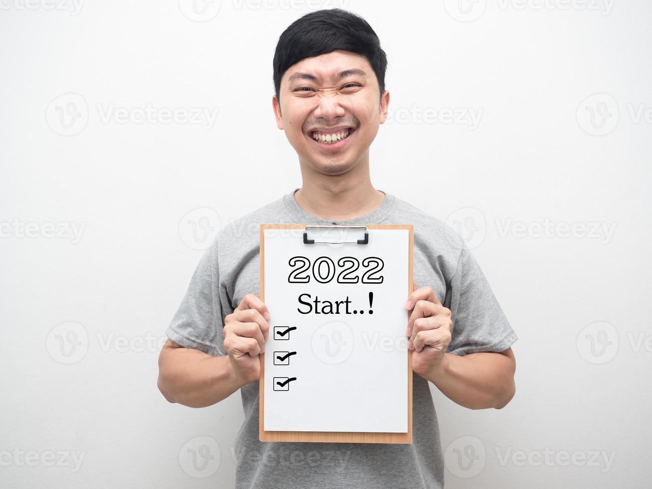 Cheerful man smiling showing document wood board with 2022 message and check list portrait photo