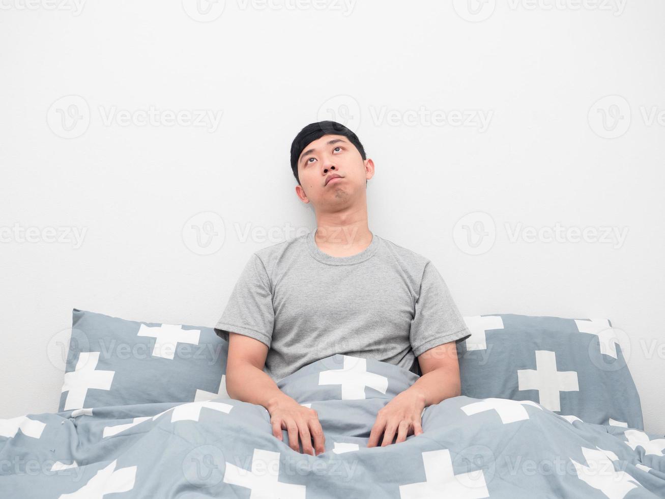 el hombre se despierta en la cama sintiéndose aburrido y mirando hacia arriba foto