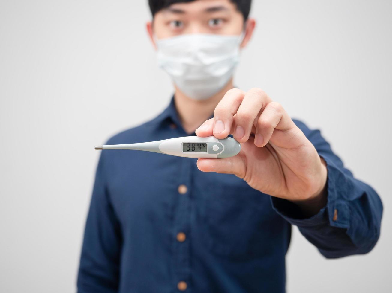 Closeup thermometer in man hand high temperature on white background photo