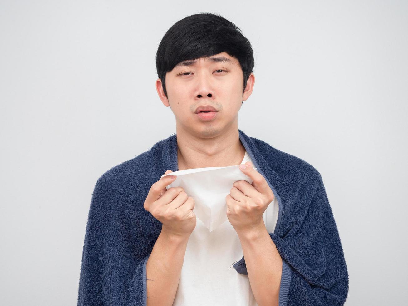 Asian man with towel holding tissue and sneeze unwell face,Sick man concept photo