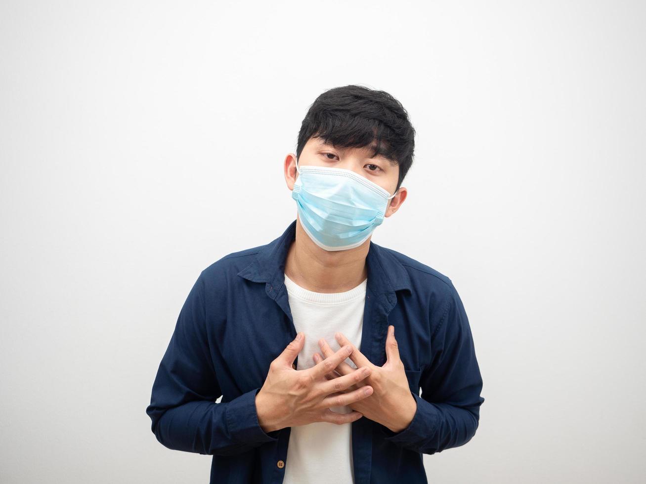 Thai man with protect mask touch his heart feel bad and sick looking at camera on isolated white photo