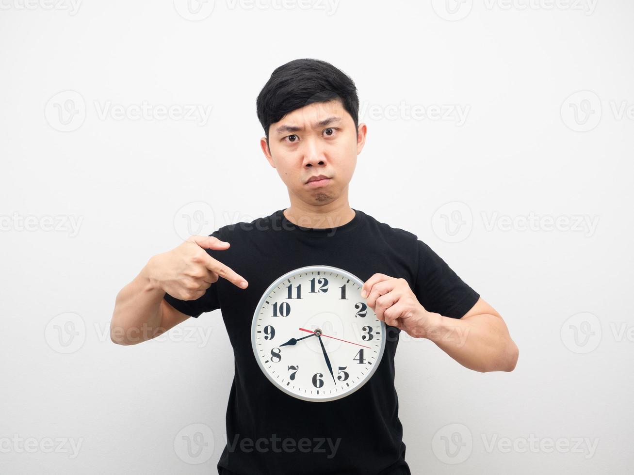 Man point finger at clock in hand feeling angry photo