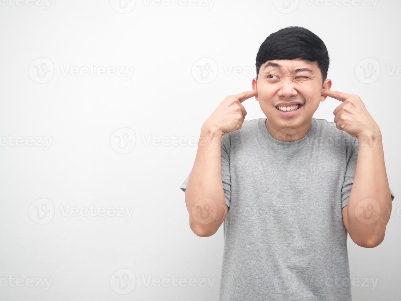 Man gesture plug finger close his ear and looking at copy space white background photo