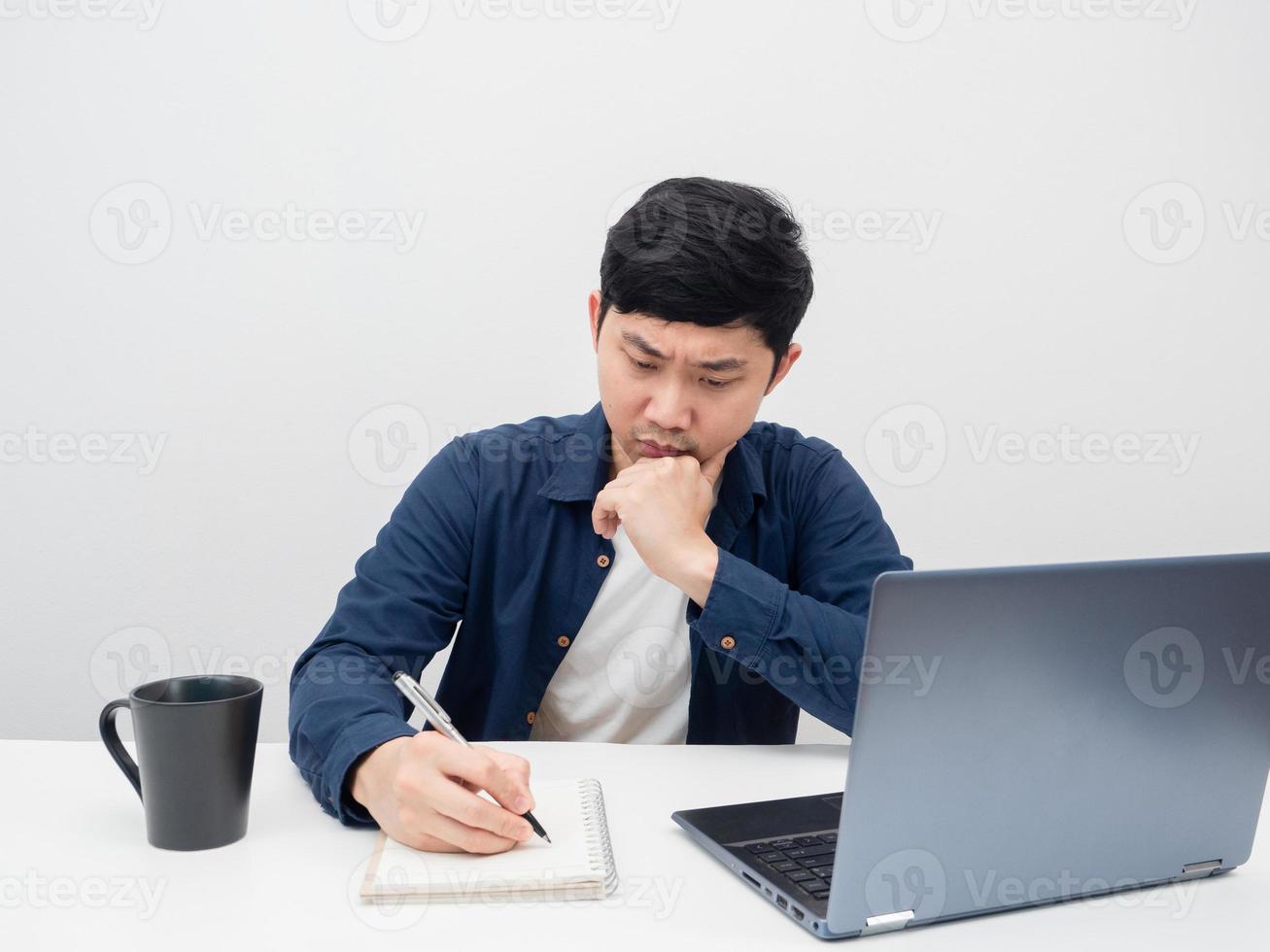 Man writing at notebook on the desk with laptop white background photo