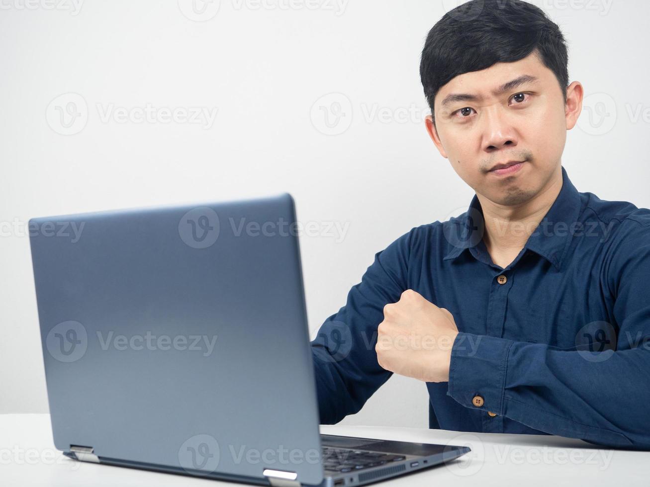 hombre trabajador con gesto de laptop confiado y mirando a la cámara foto