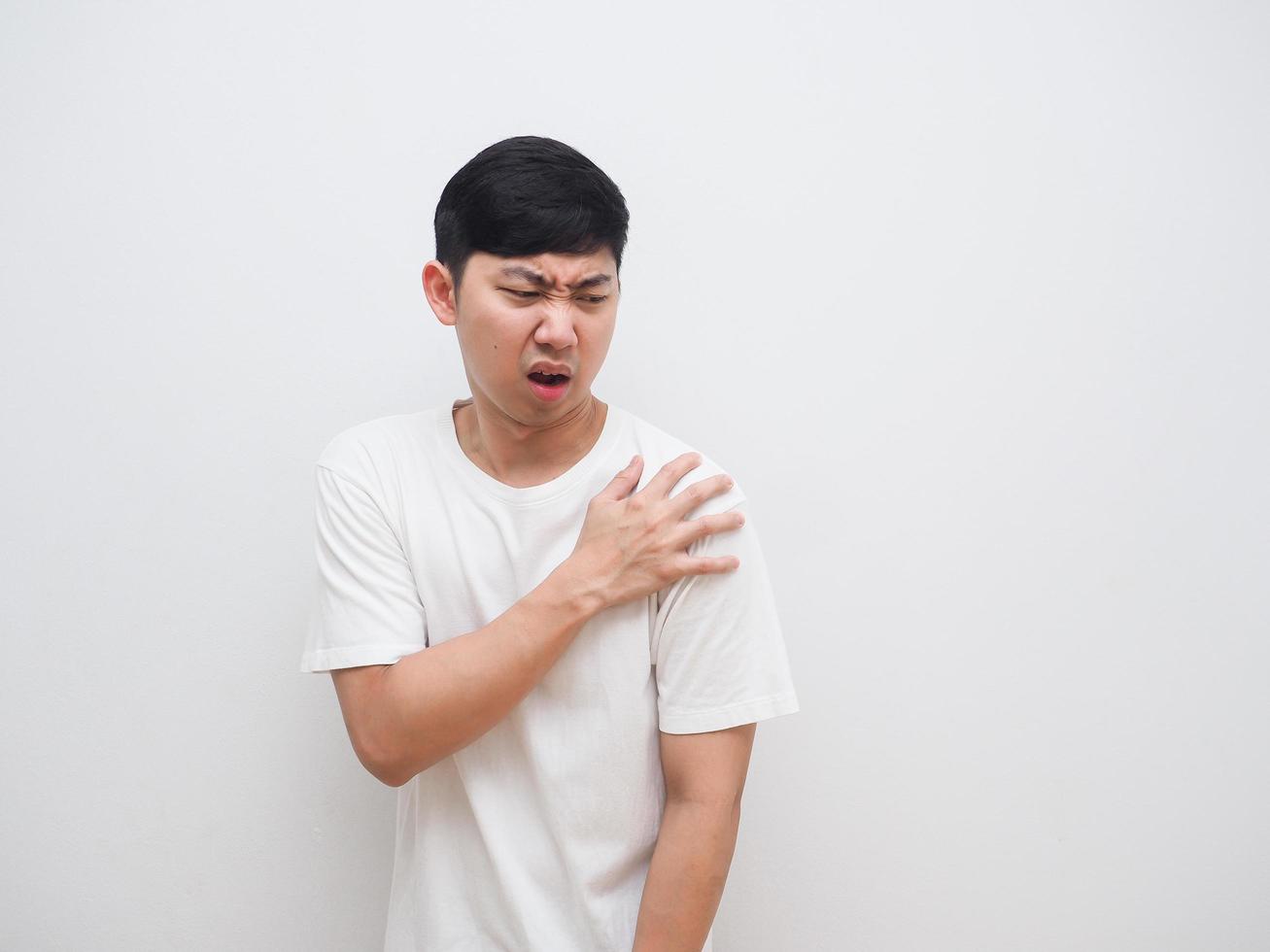 Asian man feel pain at his shoulder and touch his shoulder by right hand on white background photo