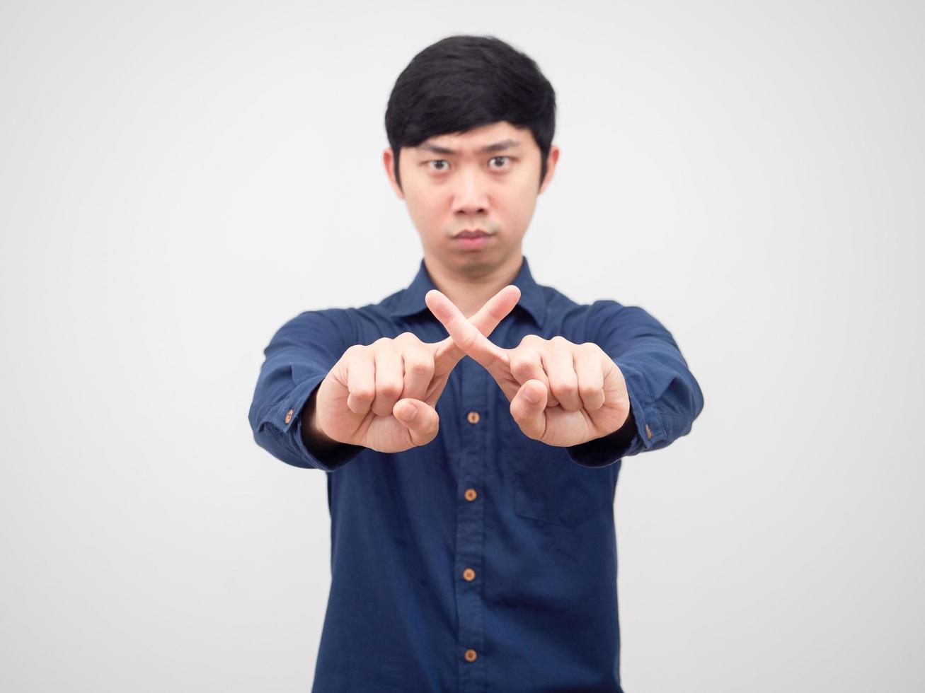 Asian man show cross finger hand with serious face white background photo