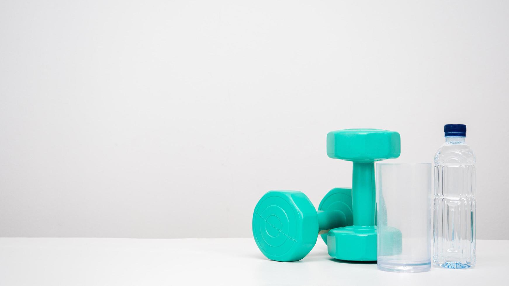 Dumbbell with water bottle on the table white background copy space photo