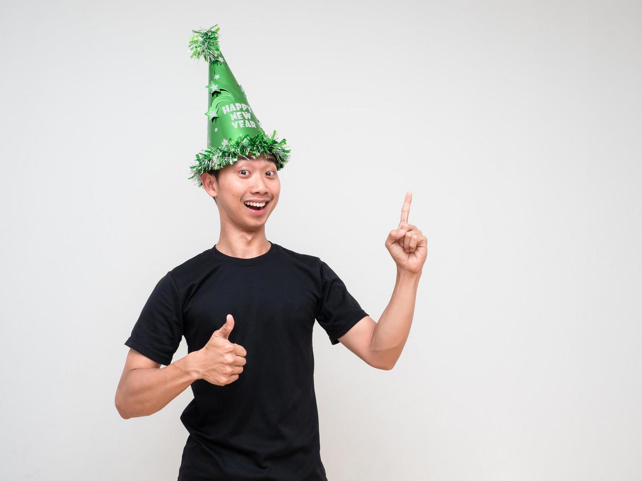 Young Asian man happy face look at camera with green hat point right finger above thumb up and happy smile on white isolated background photo