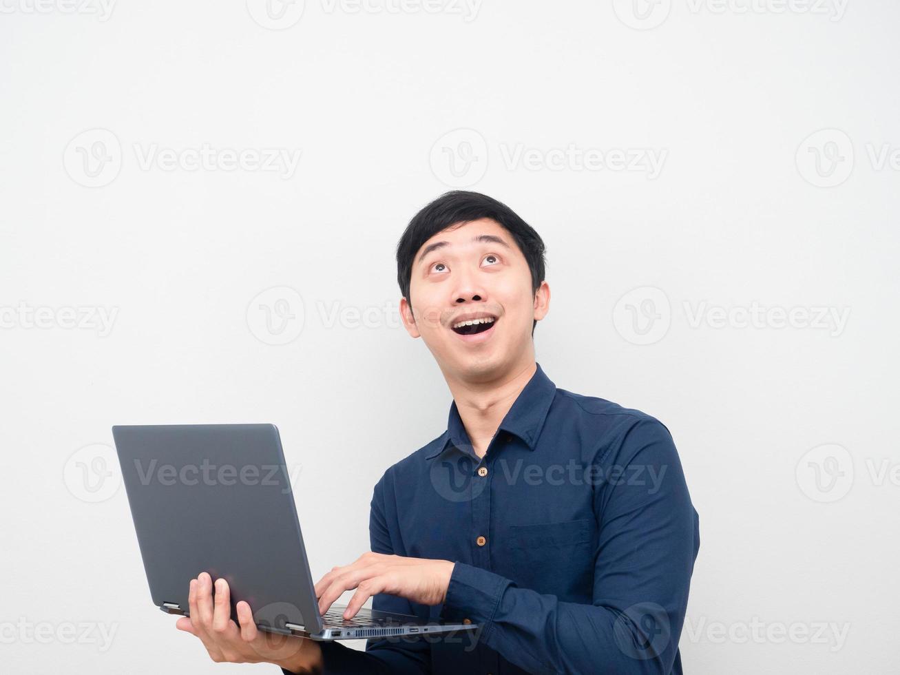 hombre que sostiene la computadora portátil que se siente emocionado mirando el espacio de la copia foto