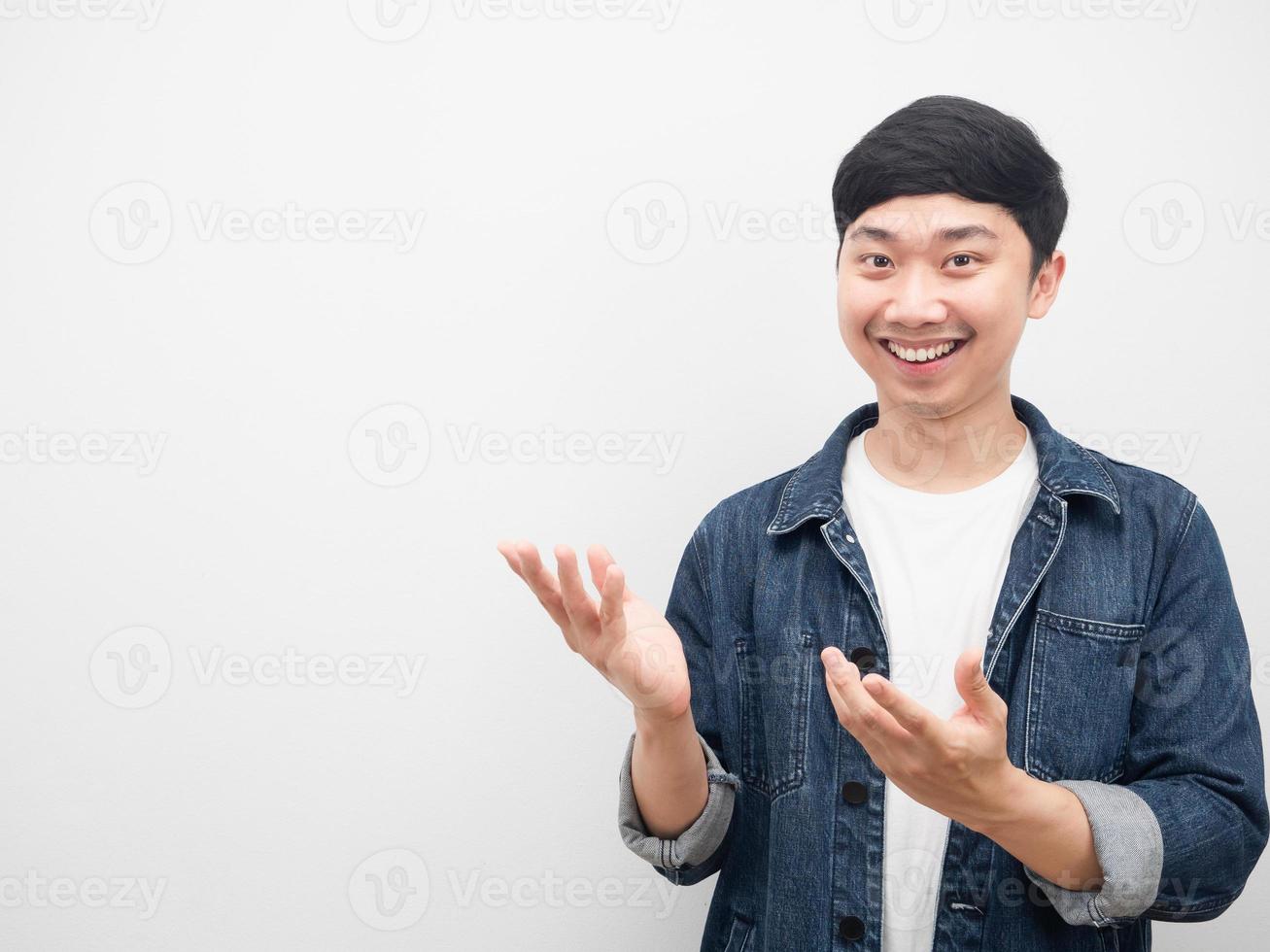 Asian man jeans shirt smiling gesture pointing hand at copy space photo