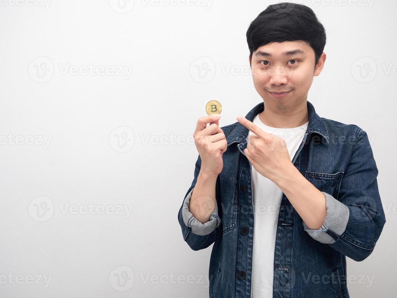 Man jeans shirt point finger at golden bitcoin in hand copy space photo