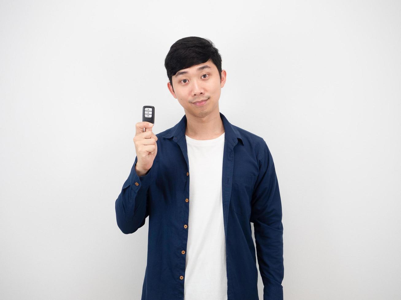 Asian man holding car key with happy smile on white background photo