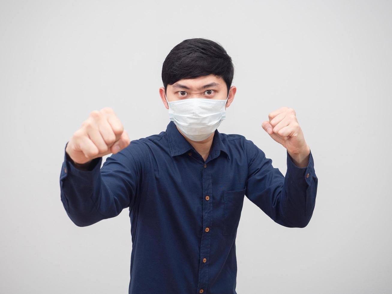 Asian man wearing protect mask stance and punch serious face on white background photo