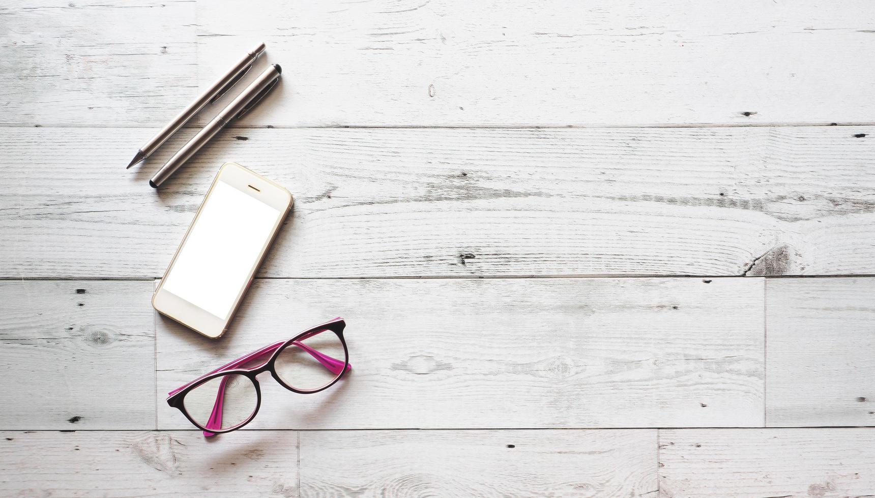 Two silver pen with smartphone and glasses on white wood table nature shadow and light top view space,Business concept photo