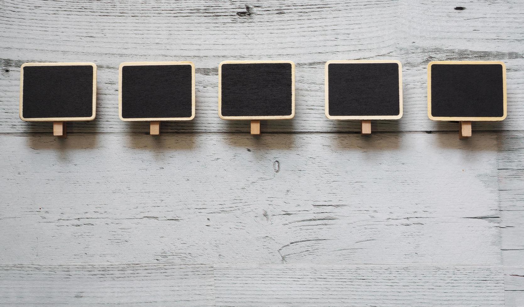 Five small clip chalkboard array line on white wood table nature shadow below space,Idea signboard concept photo