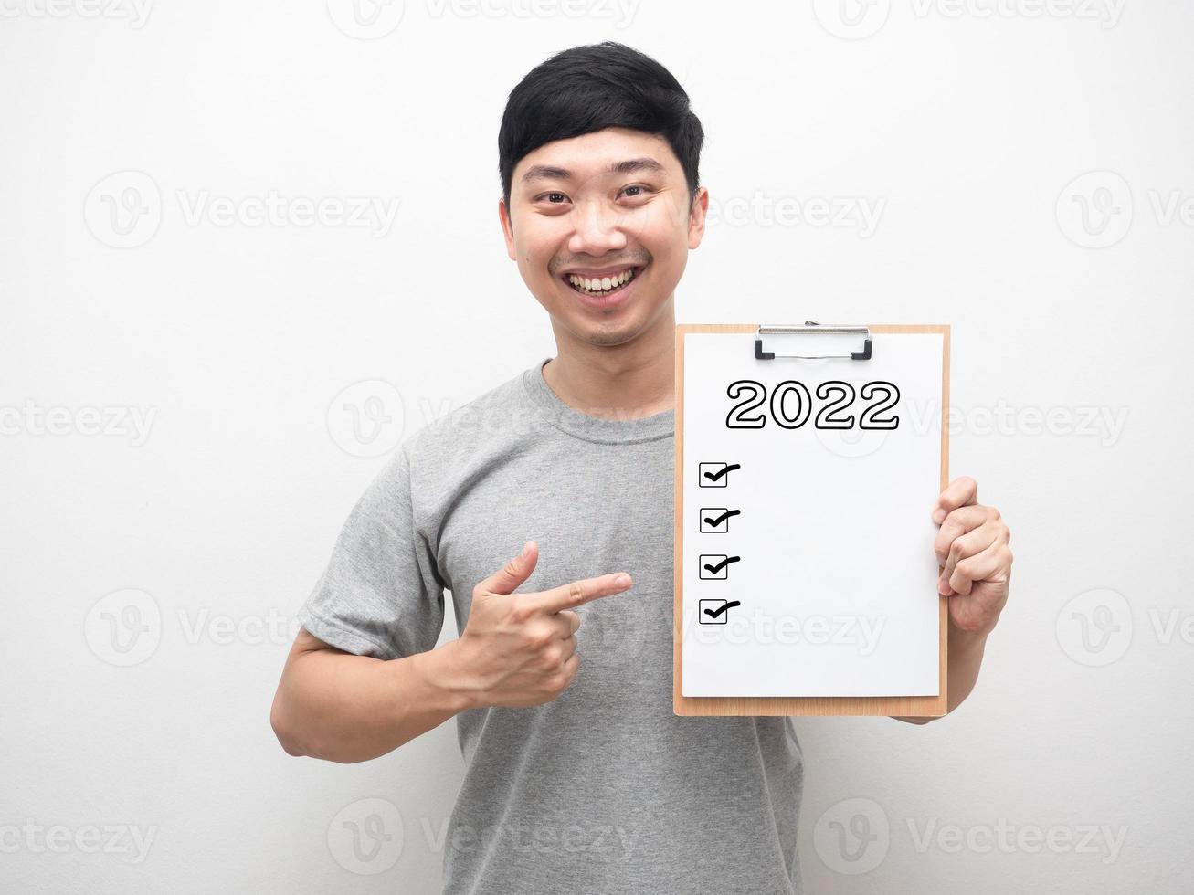Man smiling point finger at document wood board with 2022 message and check list photo
