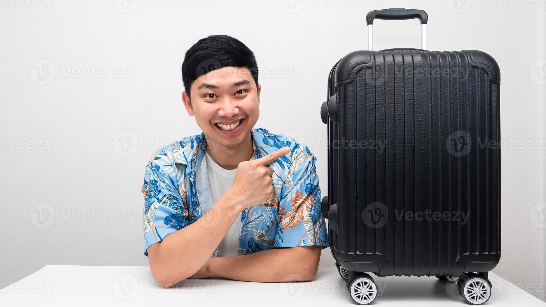 Man blue shirt point finger at luggage smiling photo