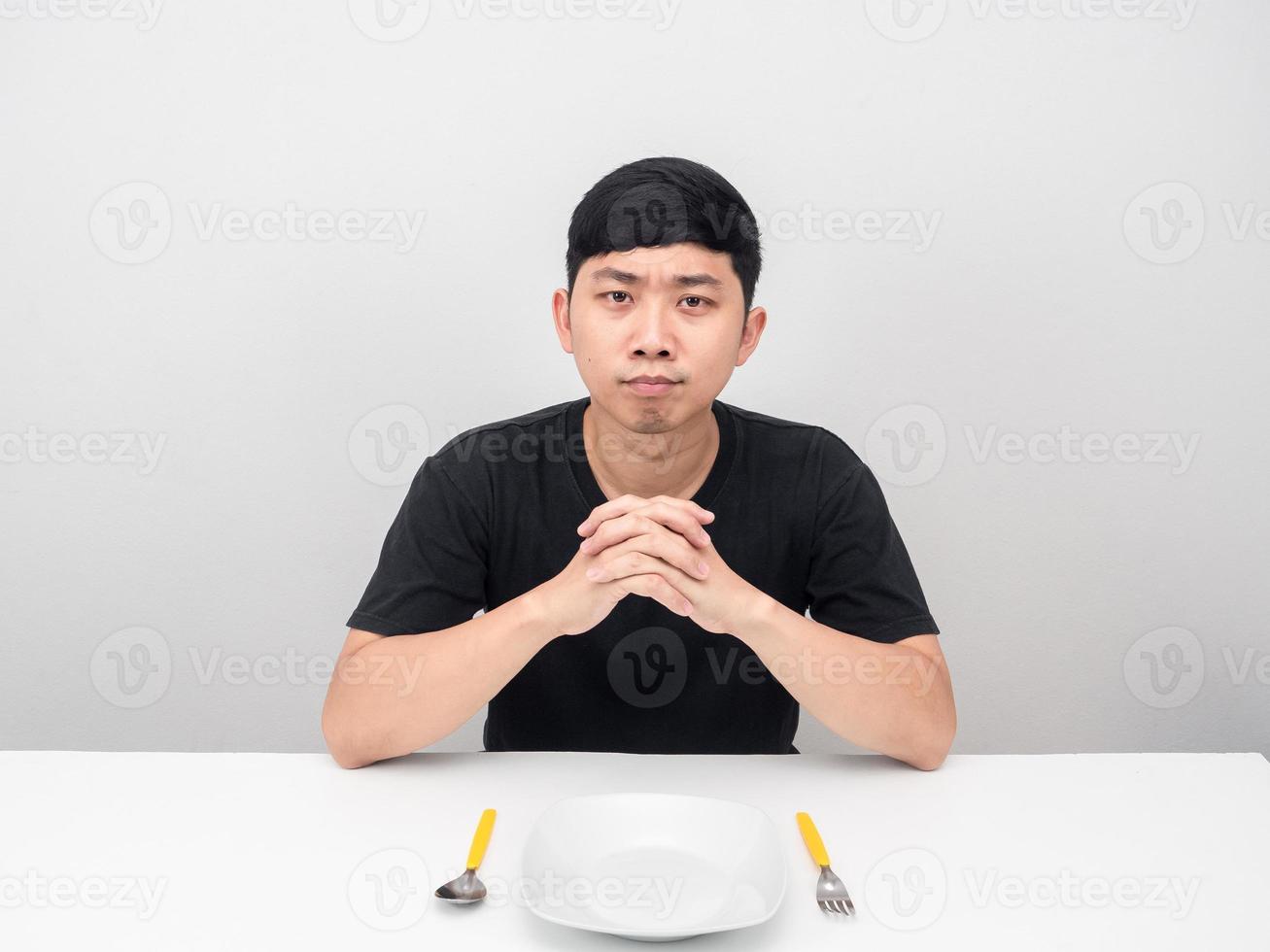 el hombre se sienta a la mesa con un plato esperando la cena y la comida foto