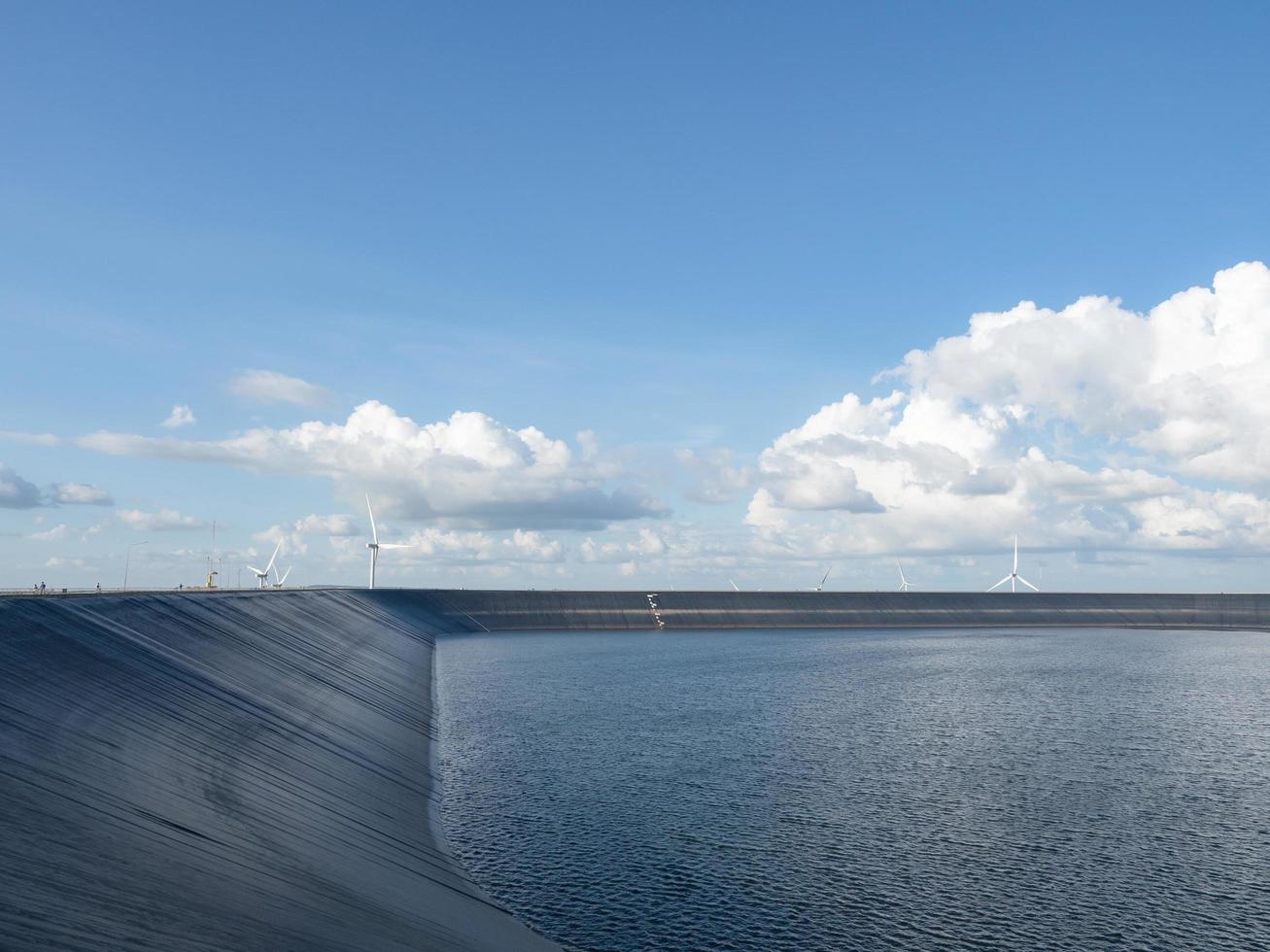 Reservoir on the mountain landscape with wind turbine and cloudy on blue sky,Water in reservoir photo