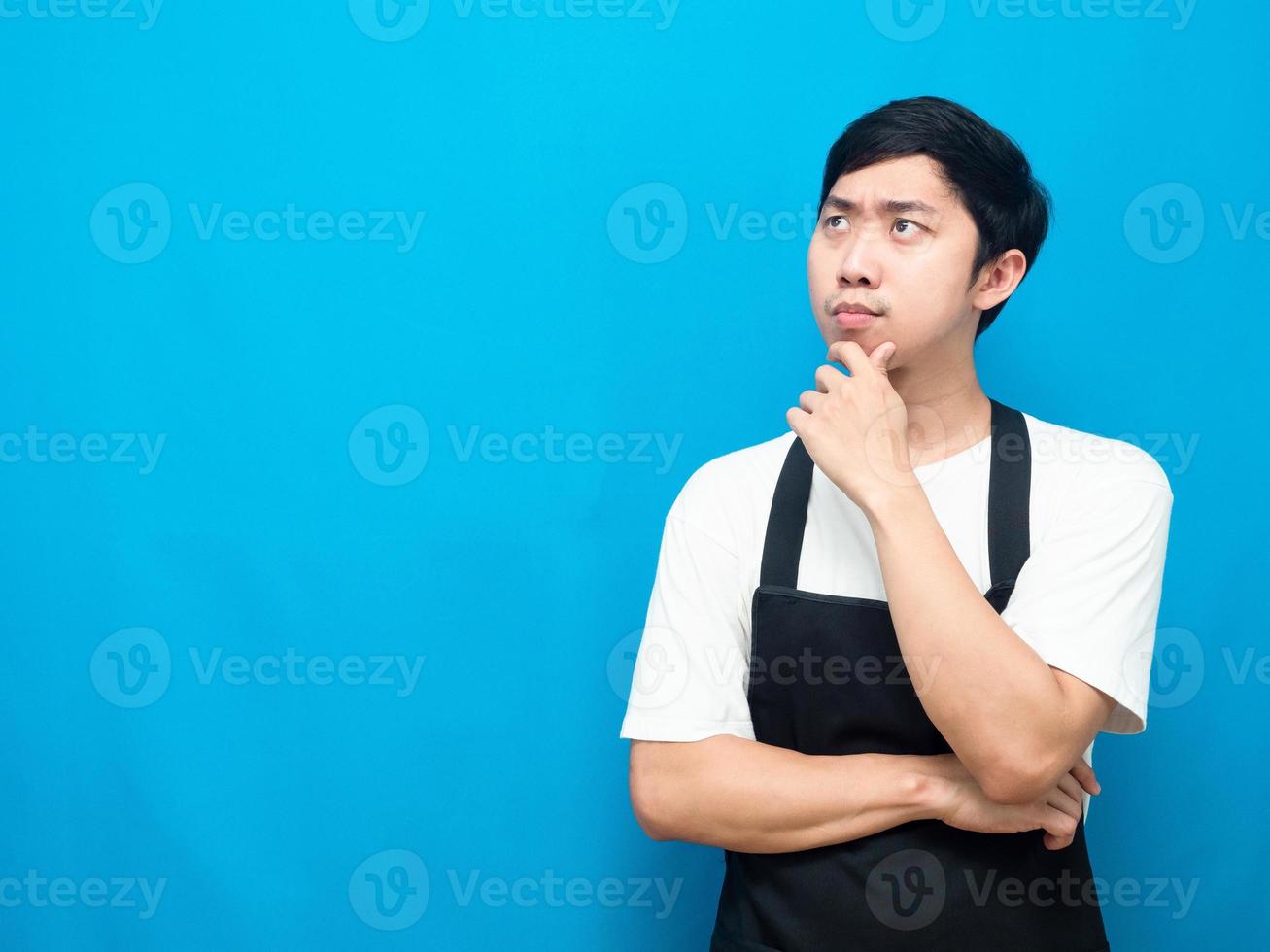 Man wearing apron gesture thinking about something looking at copy space photo