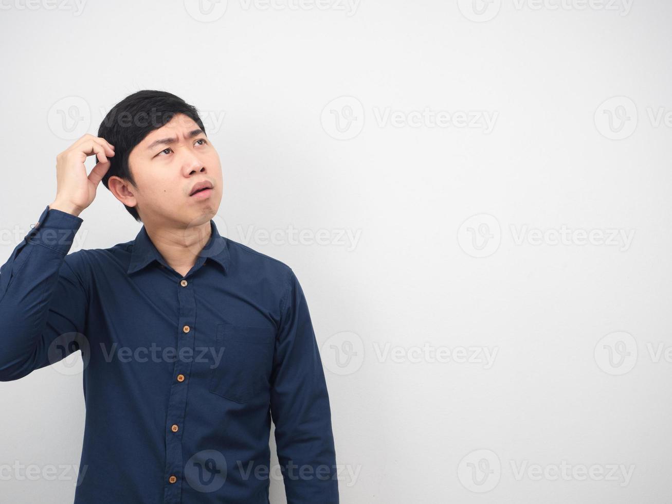 Man scratch his haed feeing confused and looking at copy space photo