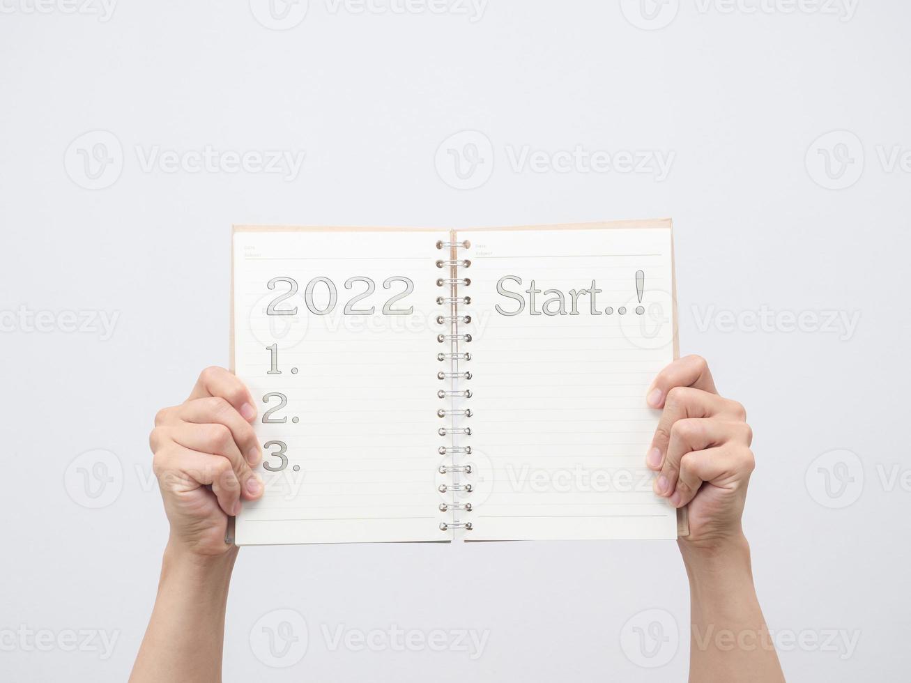 Hand showing blank page diary with 2022 and start message check list photo