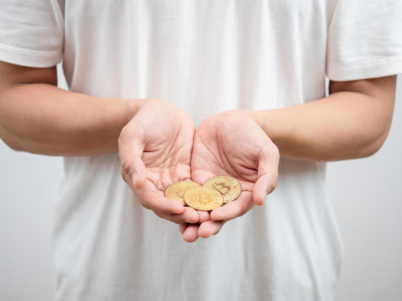 Close up man hand holding golden bitcoins portrait photo