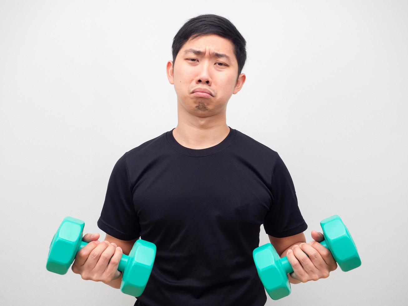 Man holding drumbbell feeling bored to workout sad emotion photo