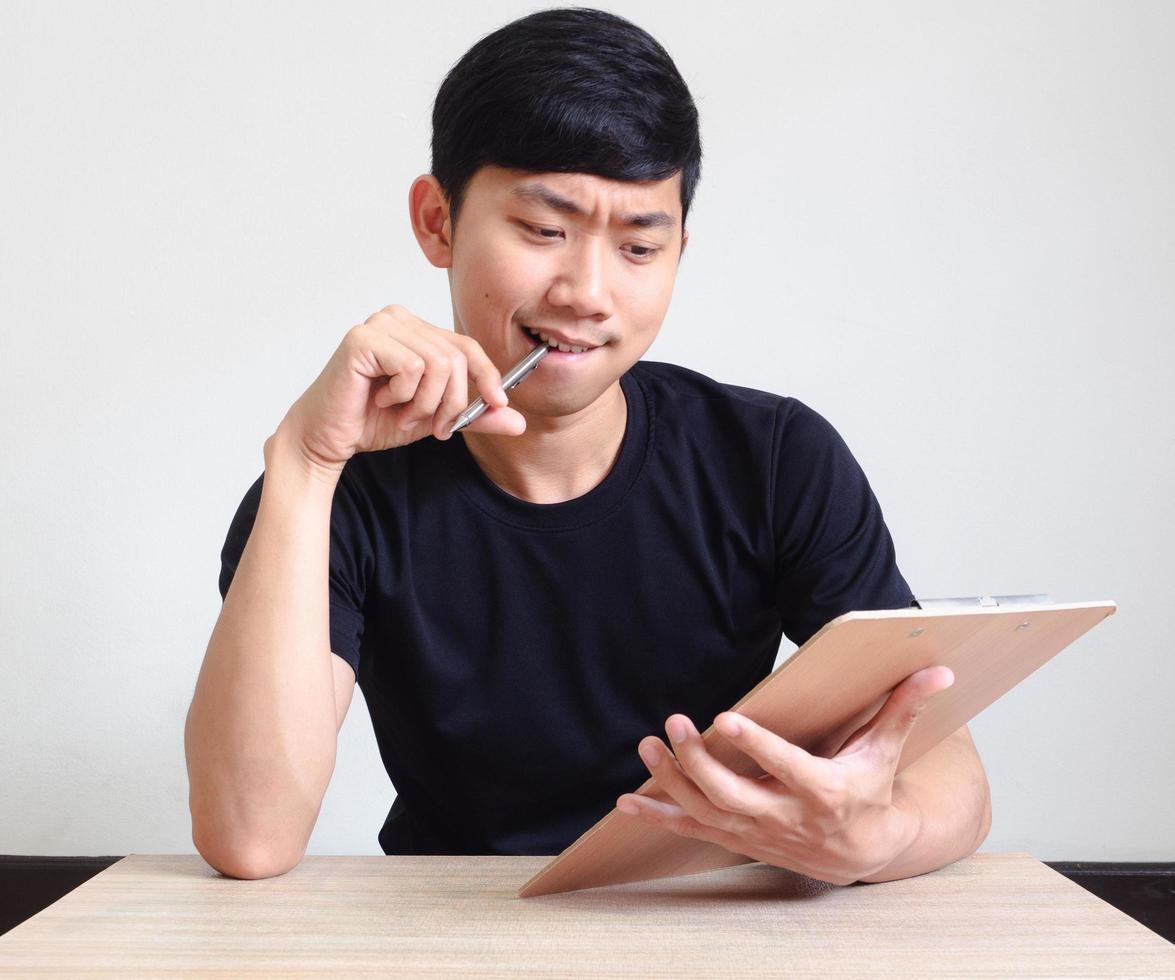 Young man with pen think and serious face with the book on the desk look at camera on white isolated,Study book concept photo