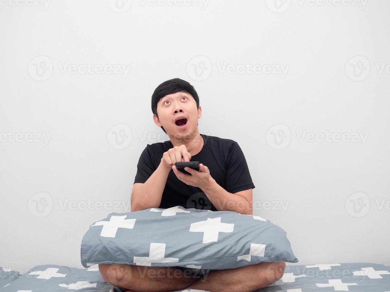 Man using mobile shopping online on the bed feeling excited photo