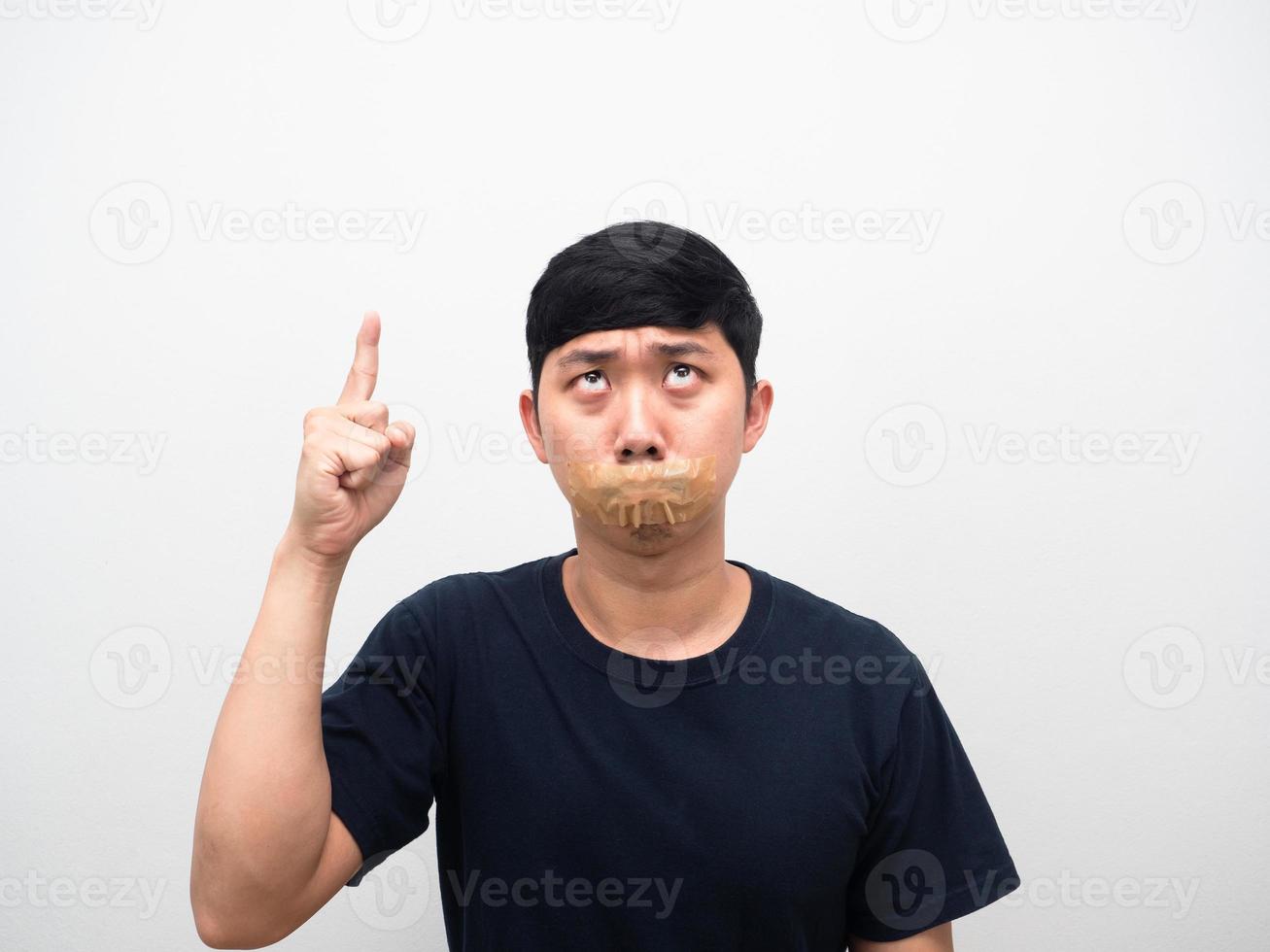 Man tape close mouth point finger above copy space photo